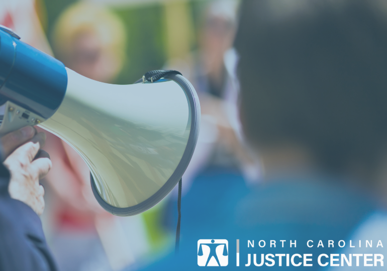 Organizer speaking into bullhorn to crowd.